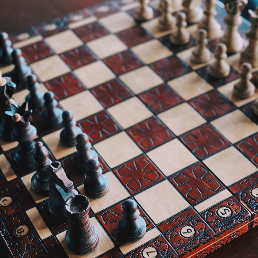 An ornate wooden chess board and pieces